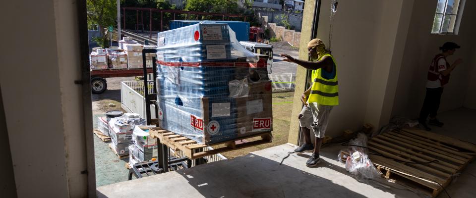 A photo showcasng aid items being placed in storage by aid workers