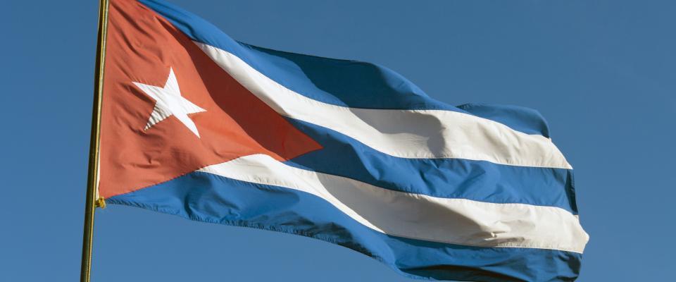 Cuba flag A flag with red, white, and blue stripes waves against a clear blue sky.