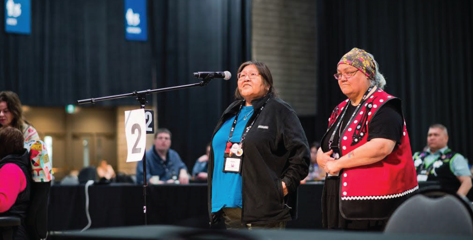 Delegates standing to speak during a meeting at the PSAC National Event.