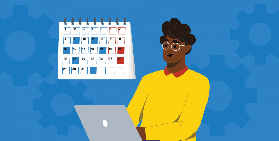 A person working on a laptop in front of a calendar