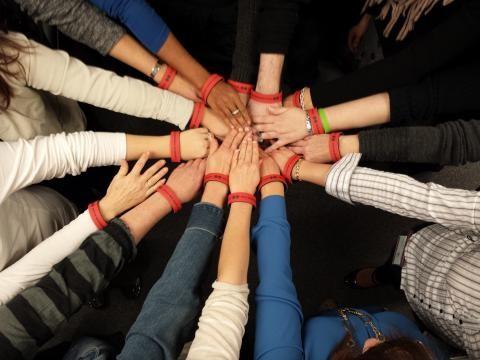 A photo of a number of peoples' hands touching in a circle