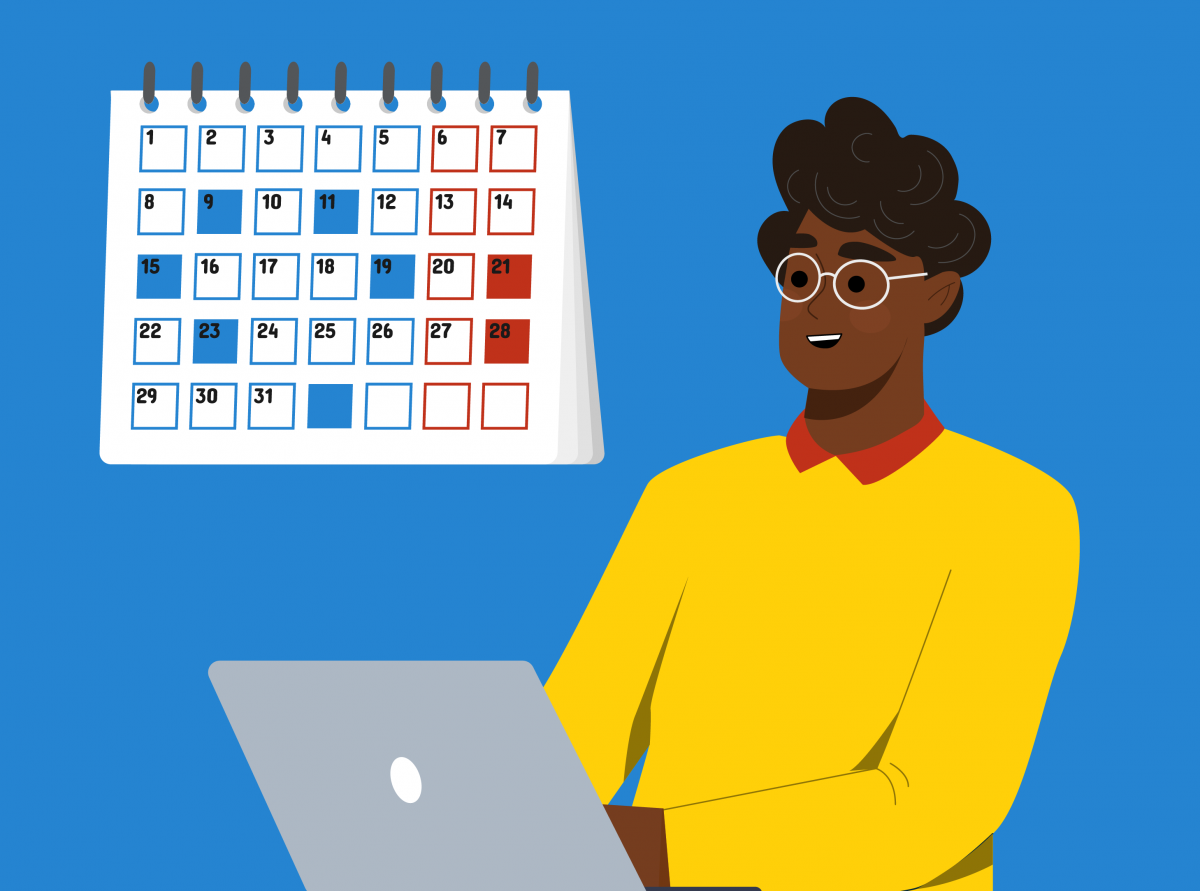 A person working on a laptop in front of a calendar